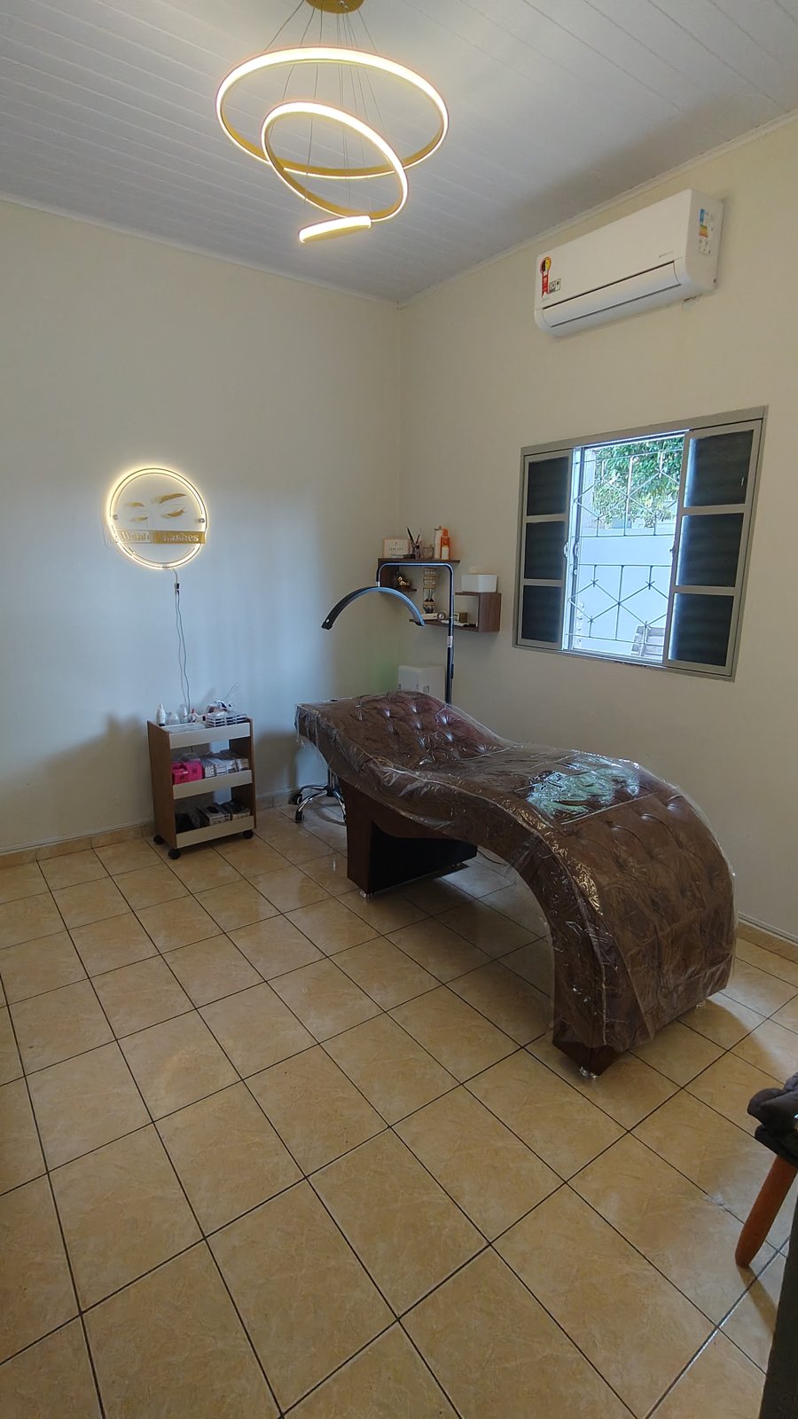 Maca de atendimento do estúdio Wish Lashes com luminária de anel e letreiro iluminado