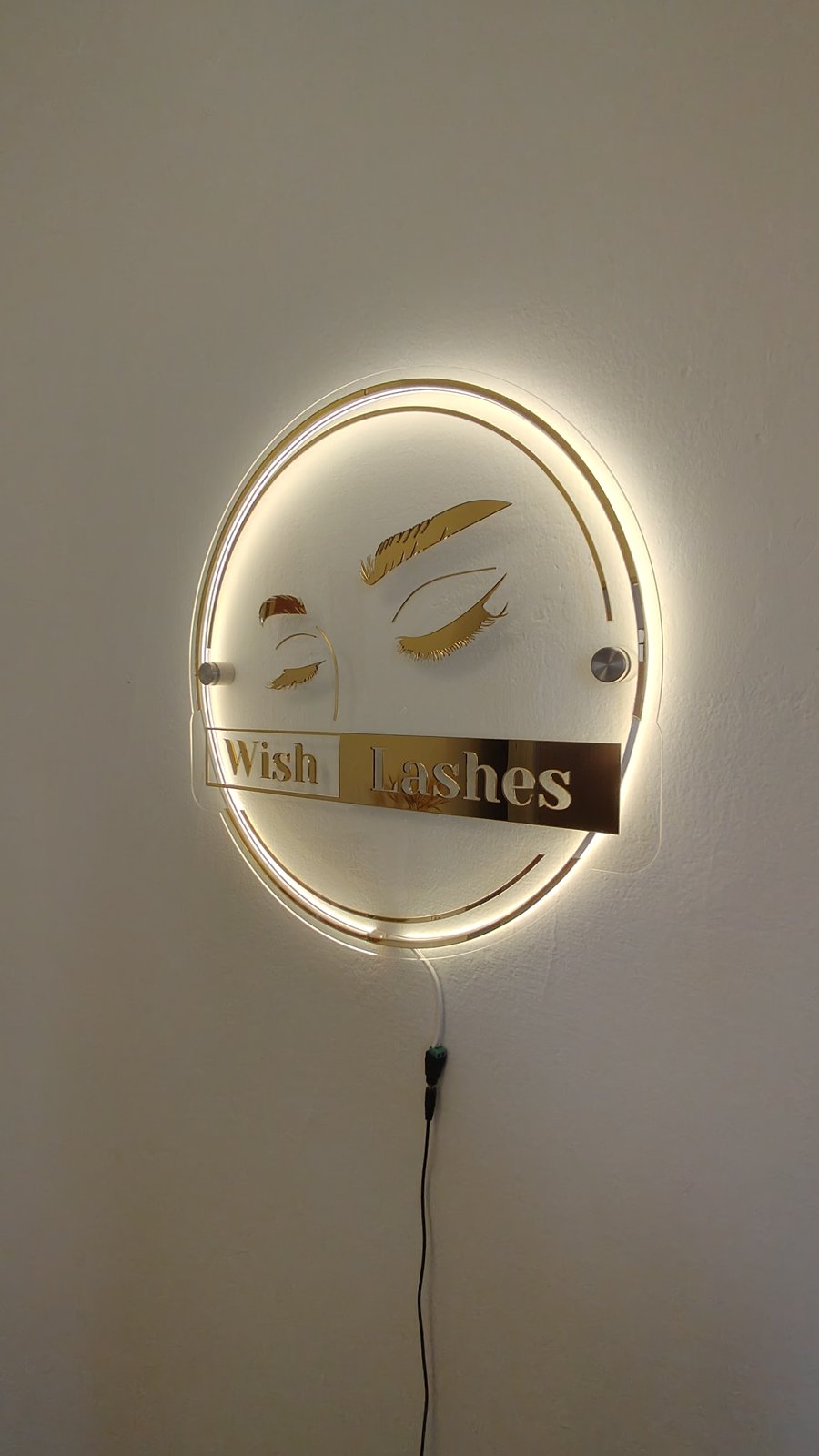 Letreiro iluminado Wish Lashes na parede do estúdio